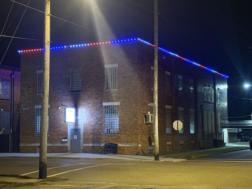 Permanent red, white and blue trim lighting on a commercial brick building roofline